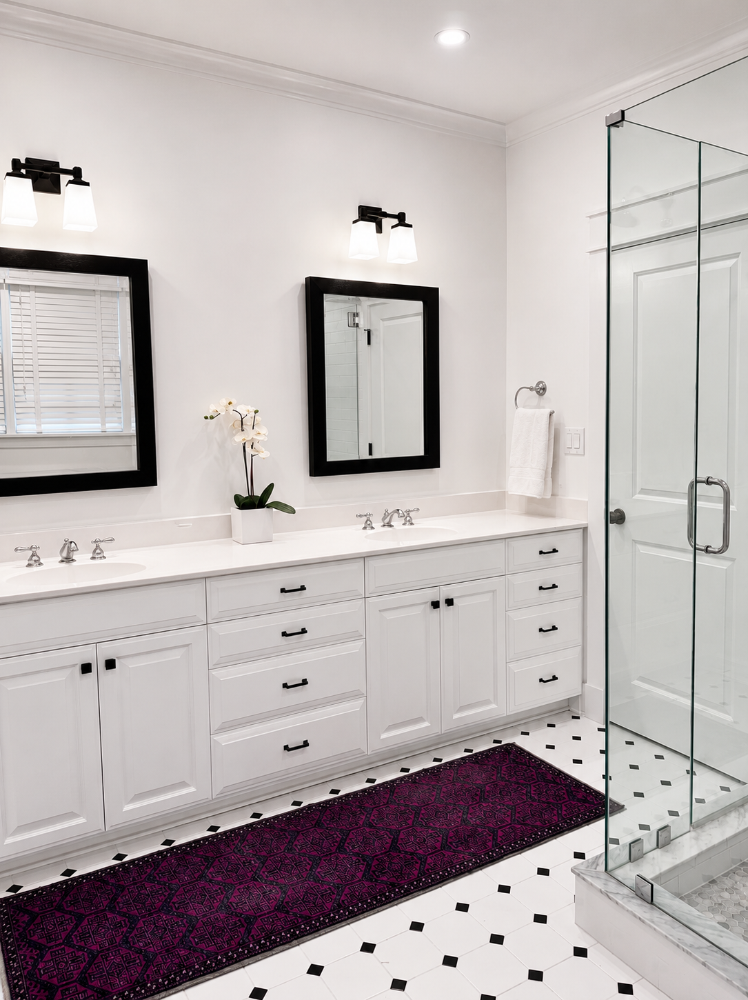 Primary bathroom off the suite with double vanity, glass shower, and black-and-white tile floor